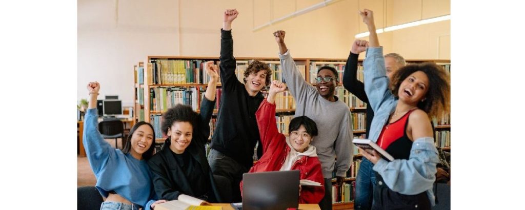 Happy university students cheering in a library